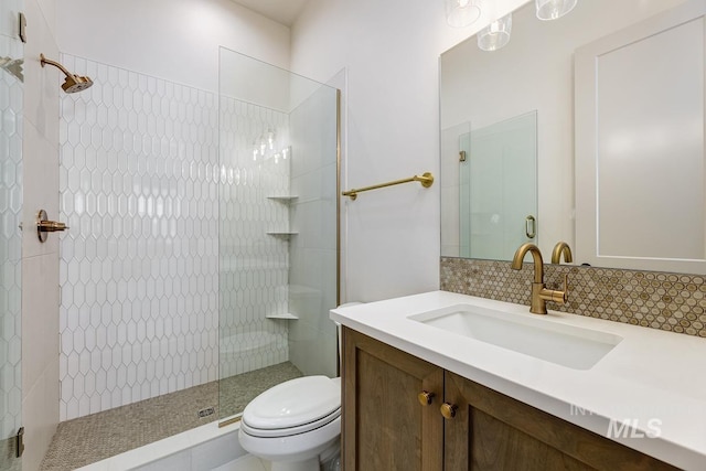 full bath with backsplash, toilet, tiled shower, and vanity