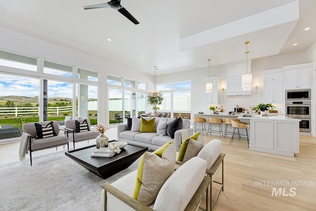 living area with a ceiling fan, recessed lighting, and light wood-style flooring