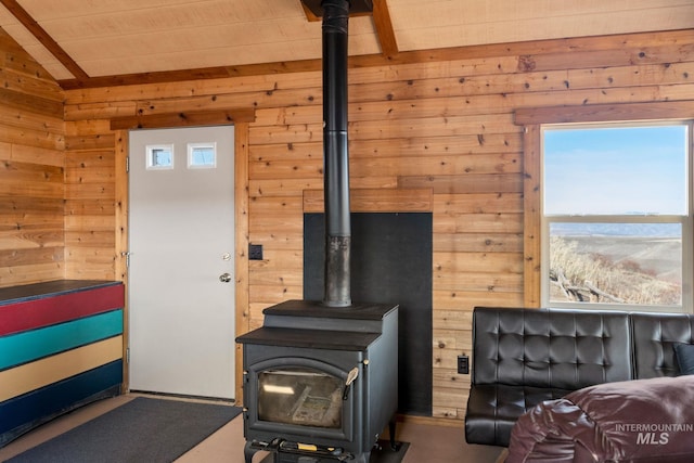 living room with a wood stove, wood walls, and vaulted ceiling