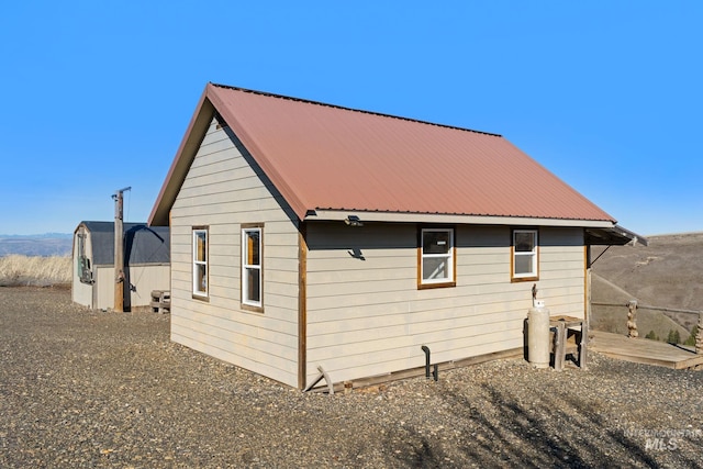 view of side of home with metal roof and an outdoor structure