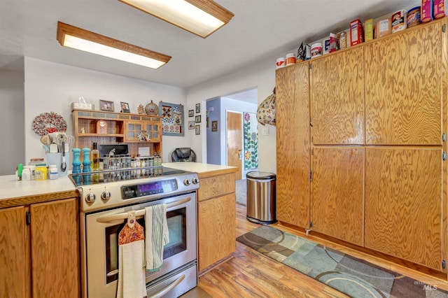 kitchen featuring stainless steel range with electric stovetop and light wood-type flooring