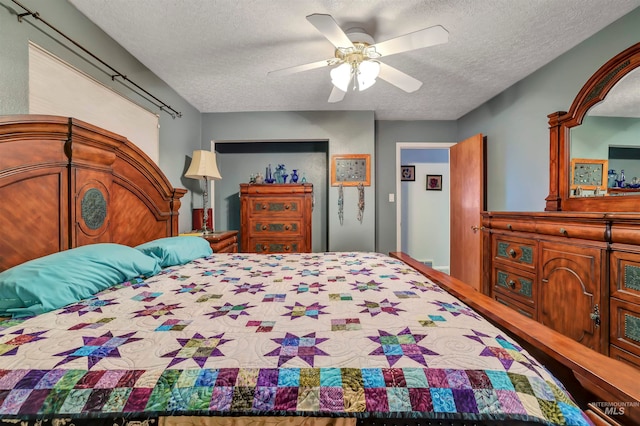 bedroom with a textured ceiling and ceiling fan