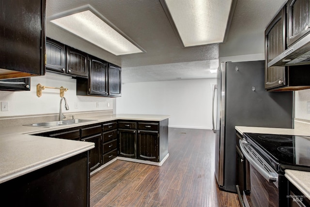 kitchen with electric stove, sink, dark wood-type flooring, wall chimney exhaust hood, and dark brown cabinetry