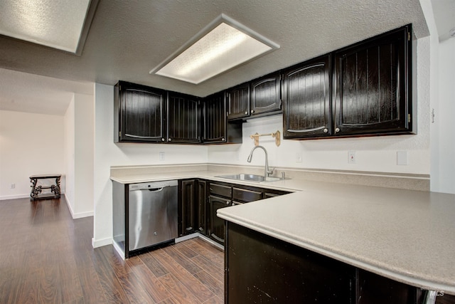 kitchen with a textured ceiling, stainless steel dishwasher, sink, and dark hardwood / wood-style flooring