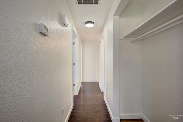 hall featuring dark hardwood / wood-style flooring and a textured ceiling