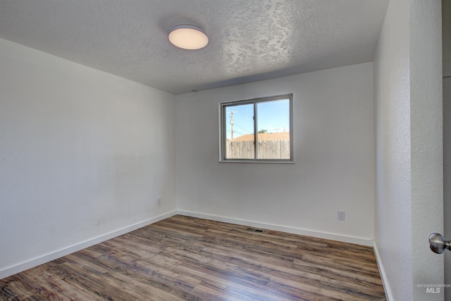 unfurnished room featuring a textured ceiling and hardwood / wood-style floors