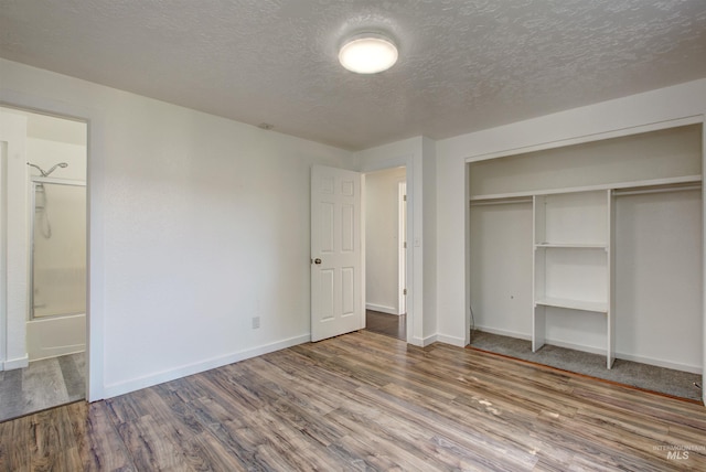 unfurnished bedroom featuring a closet, hardwood / wood-style flooring, and a textured ceiling