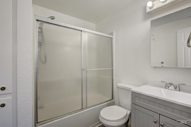 full bathroom with enclosed tub / shower combo, toilet, and vanity