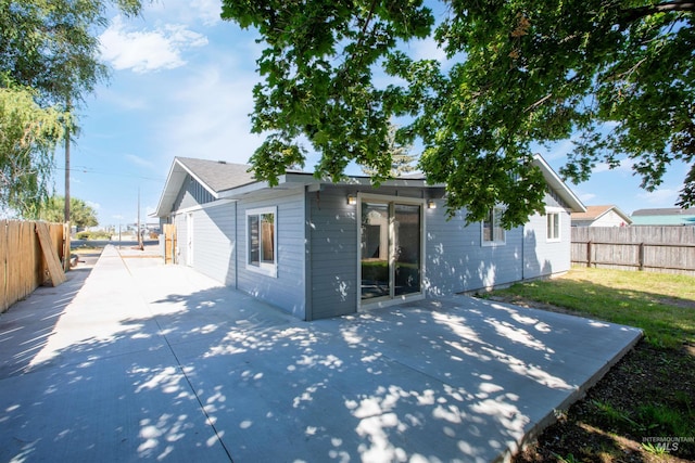 back of property featuring a lawn and a patio area