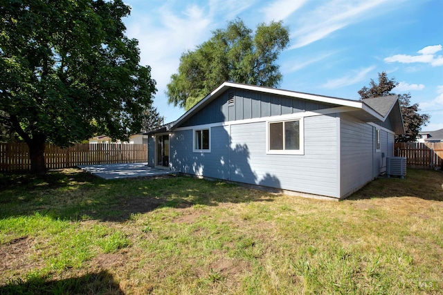 back of house with central AC, a yard, and a patio area