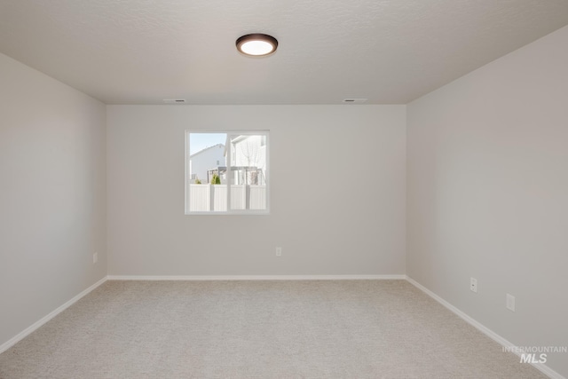 empty room featuring carpet floors and a textured ceiling