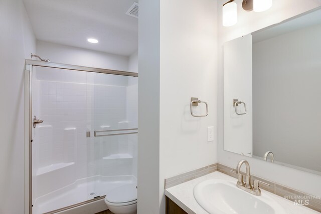 bathroom featuring vanity, toilet, and walk in shower