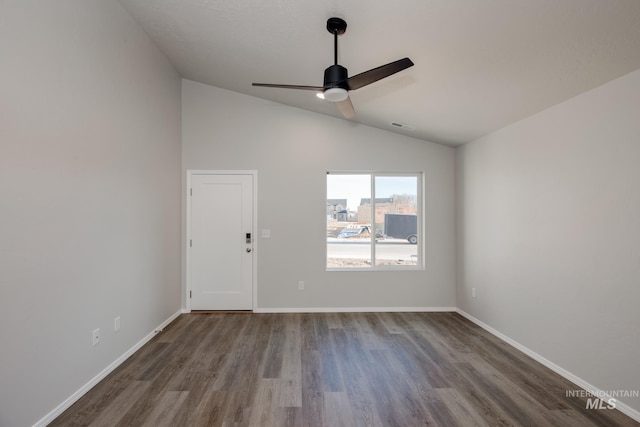 empty room featuring wood-type flooring, ceiling fan, and vaulted ceiling