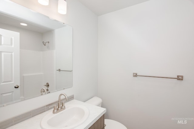 bathroom with walk in shower, vanity, and toilet