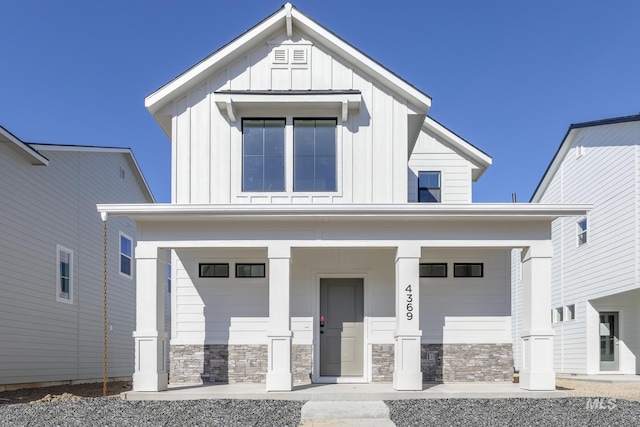 4429 N Magical Creek Ave, Meridian, ID 83646 - view of front of property featuring board and batten siding, a porch, stone siding, and a garage