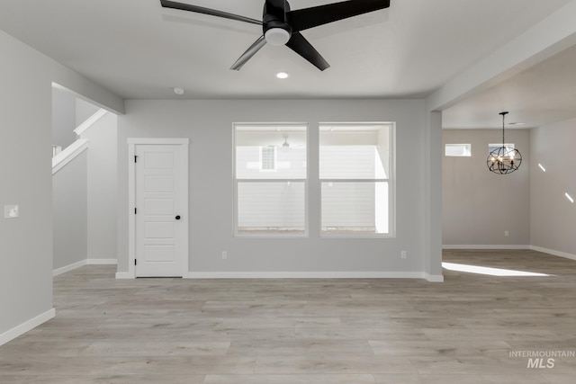 4429 N Magical Creek Ave, Meridian, ID 83646 - unfurnished living room with a chandelier, ceiling fan, baseboards, light wood-style flooring, and recessed lighting