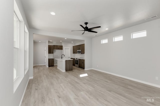 4429 N Magical Creek Ave, Meridian, ID 83646 - unfurnished living room with a ceiling fan, light wood-style floors, baseboards, recessed lighting, and a sink