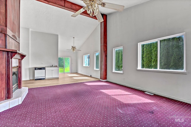 unfurnished living room with ceiling fan, light carpet, high vaulted ceiling, and sink