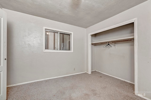 unfurnished bedroom featuring carpet, a closet, and a textured ceiling