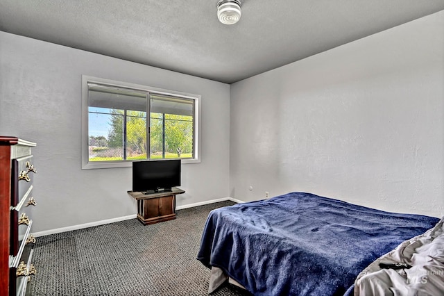 bedroom featuring a textured ceiling and dark colored carpet