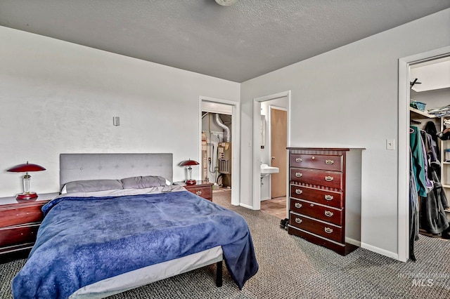 bedroom featuring carpet, a closet, ensuite bathroom, and a textured ceiling