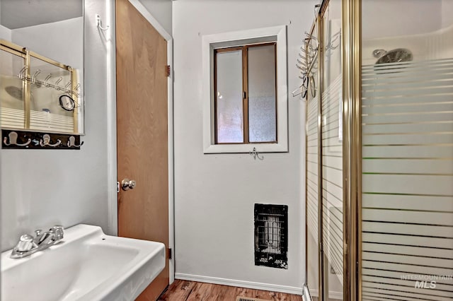 bathroom with sink, wood-type flooring, and a shower with door