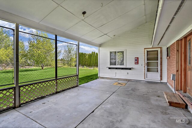 unfurnished sunroom featuring a wealth of natural light and vaulted ceiling