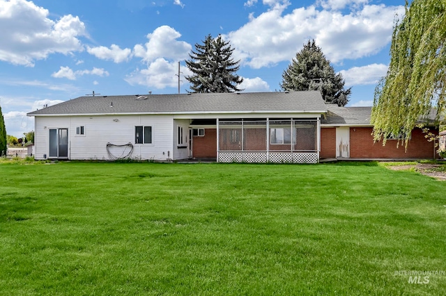 rear view of house featuring a lawn