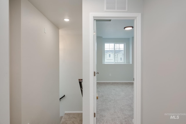 hall with light colored carpet