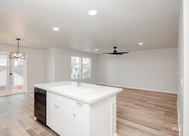 kitchen featuring dishwasher, a center island with sink, sink, hanging light fixtures, and white cabinetry