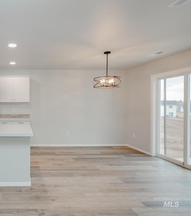 empty room featuring light hardwood / wood-style floors and an inviting chandelier