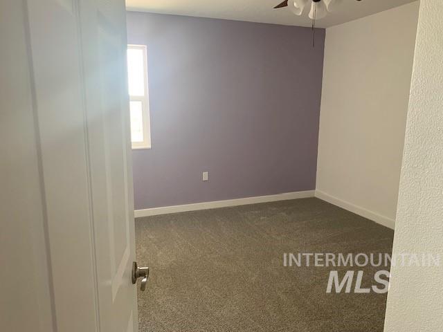 5720 SE 3rd Ave, New Plymouth, ID 83655 - empty room featuring ceiling fan, dark carpet, and baseboards