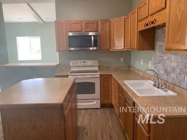 5720 SE 3rd Ave, New Plymouth, ID 83655 - kitchen with stainless steel microwave, white electric stove, a sink, tasteful backsplash, and light wood finished floors