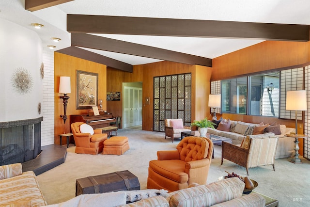 carpeted living room with brick wall, wooden walls, vaulted ceiling with beams, and a brick fireplace