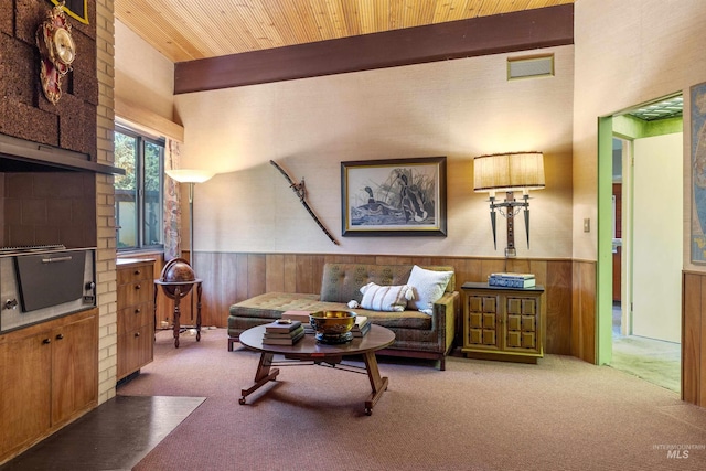 living room with carpet flooring, beam ceiling, and wood ceiling