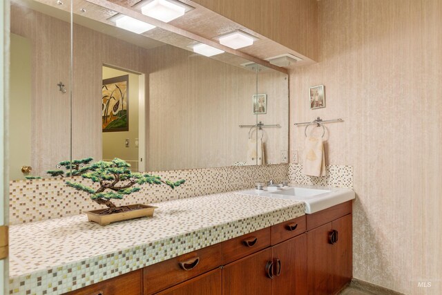 bathroom with tasteful backsplash and vanity