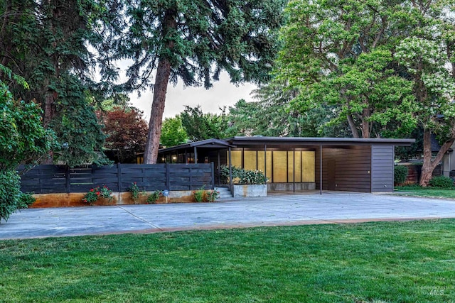 rear view of house with a carport and a lawn