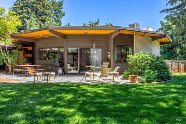 rear view of house featuring a patio and a yard