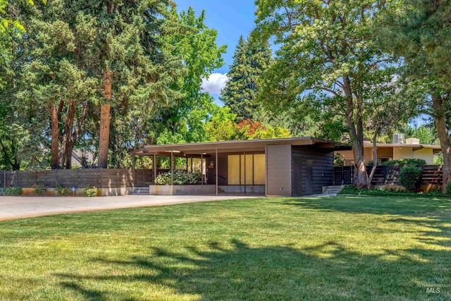 view of front of property with a carport and a front lawn