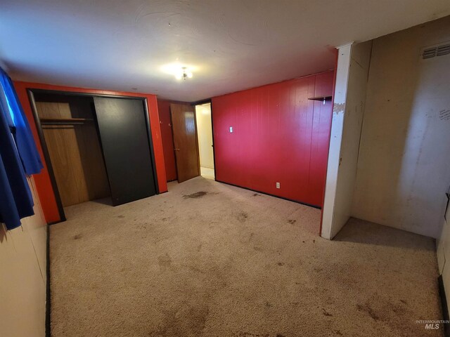 unfurnished bedroom featuring light carpet and a closet