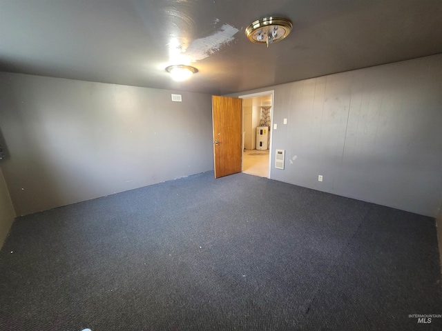 unfurnished room featuring wood walls