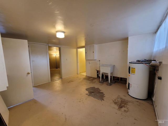 basement featuring electric panel, sink, and water heater