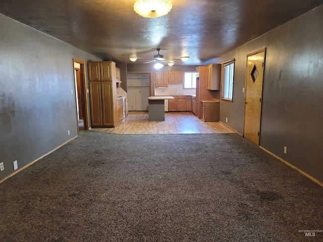 kitchen featuring a center island, sink, light wood-type flooring, and ceiling fan