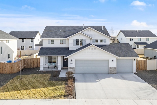 view of front of home with a residential view, roof with shingles, and fence