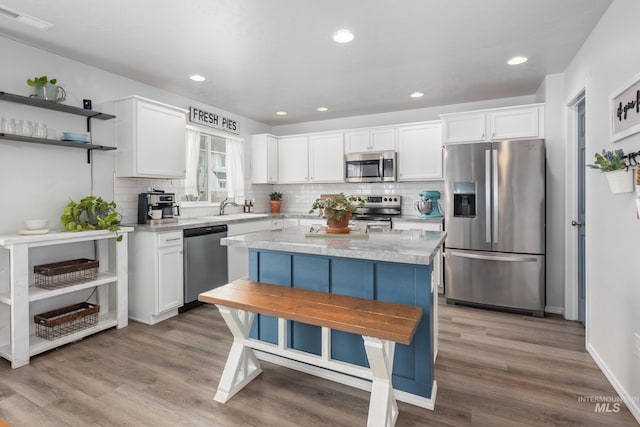 kitchen featuring stainless steel appliances, light wood finished floors, visible vents, and white cabinetry