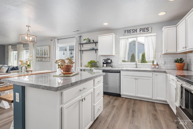 kitchen with a wealth of natural light, wood finished floors, appliances with stainless steel finishes, and a sink