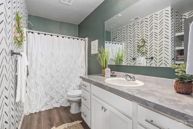 full bath with vanity, curtained shower, wood finished floors, and visible vents