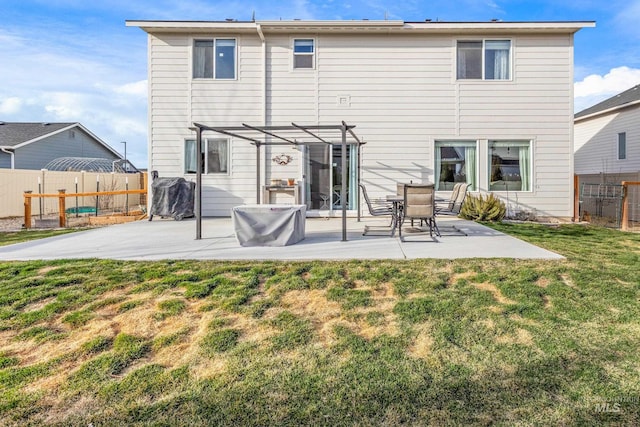 back of house with a lawn, a pergola, a patio, and fence