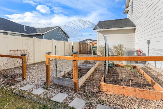 view of yard with cooling unit, a vegetable garden, and fence