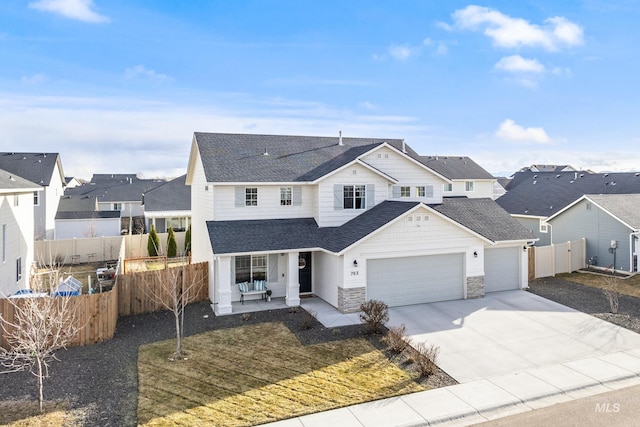 view of front of property featuring fence, a residential view, roof with shingles, driveway, and an attached garage